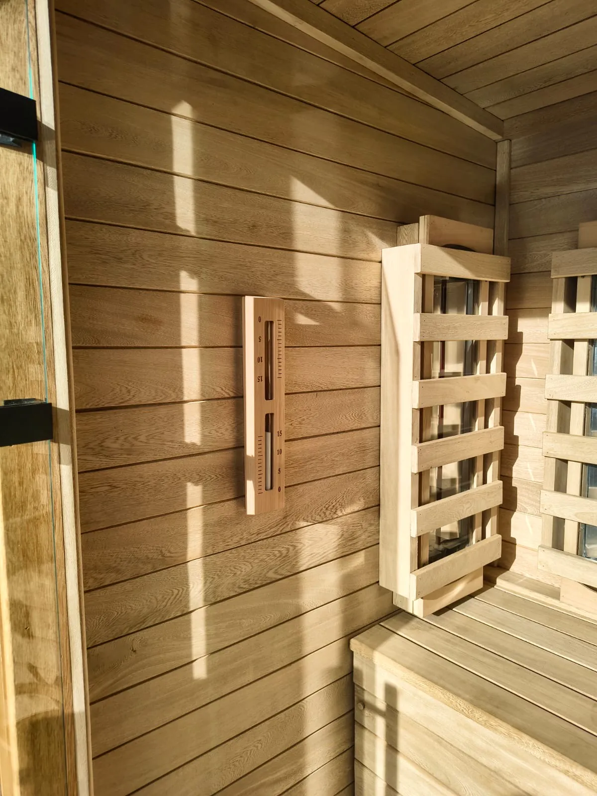 Detalle interior vertical de sauna infrarroja para 1 a 2 personas con lámparas y termómetro