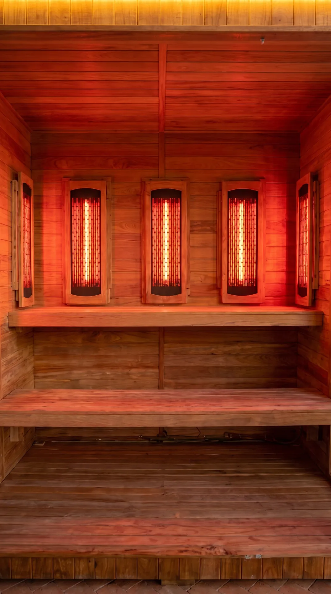 Vista vertical de las bancas y lámparas infrarrojas encendidas en sauna para 4 a 6 personas
